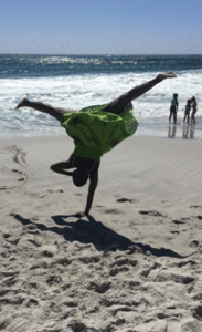 Miss Valerie doing one-handed cartwheel on the beach - showing every place is a time to dance